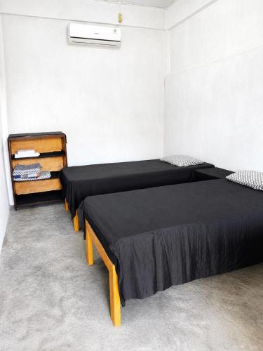 a bedroom with two beds and a dresser at Kaliele House in Domine Eduard Osok Airport
