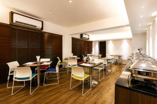 a restaurant with tables and chairs in a room at Spring Hill Service Apartments in Dhaka