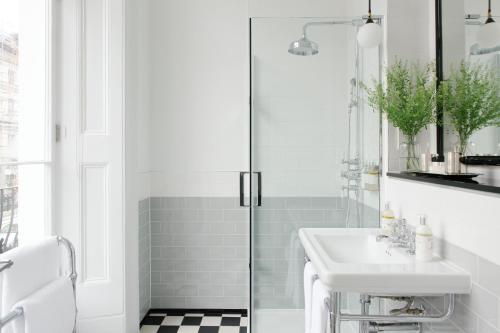 a white bathroom with a sink and a shower at The Laslett in London