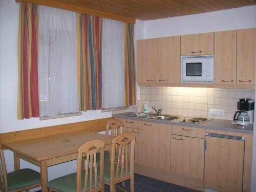 a kitchen with a table and chairs and a microwave at Hotel - Restaurant - Sonnblick in Heiligenblut