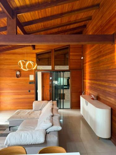 a living room with two couches in a room with wooden walls at Chalé Rossa in Xangri-lá