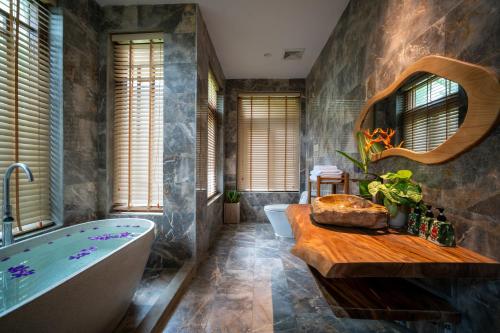 a bathroom with a bath tub and a sink at Pu Luong Eco Garden in Pu Luong