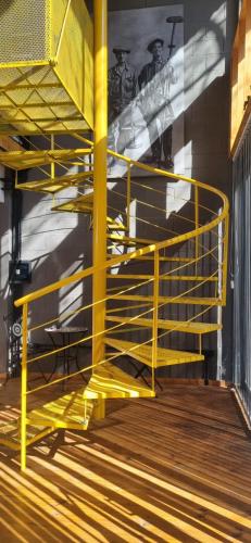 a yellow metal staircase in a room with a wall at Loft La Misión in Salta