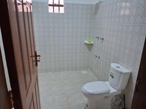 a bathroom with a toilet and a shower at BlessRoyal Home in Kitengela 
