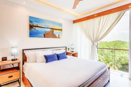 a bedroom with a bed and a large window at Eight Condos Multi Listing in Playa del Carmen