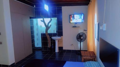 a bathroom with a tree on the wall and a sink at Happy Time guest house in Phalaborwa