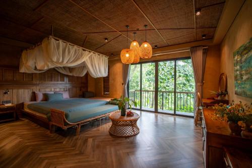 a bedroom with a bed and a large window at Pu Luong Eco Garden in Pu Luong