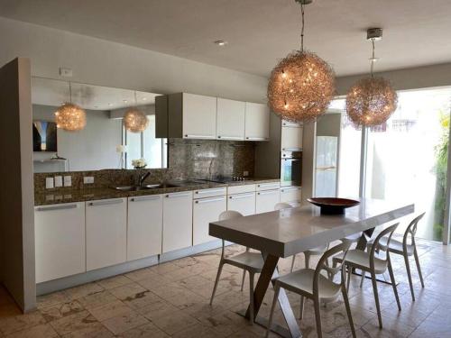 a kitchen with white cabinets and a table and chairs at Magia Multi Listings in Playa del Carmen