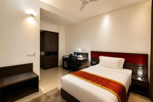 a hotel room with a bed and a desk at Spring Hill Service Apartments in Dhaka