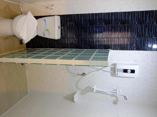 a bathroom with a shelf with a sink and toilet paper at Chada Veranda Hotel in Ban Si Than