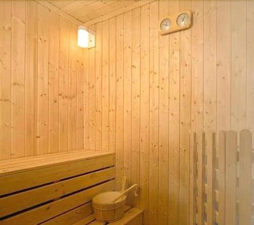 a wood paneled bathroom with a toilet and a tub at Grand Lisboa Macau in Macau