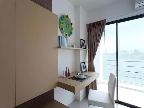 a room with a desk and a clock on the wall at Landmark Residence in Ban Khlong Sanam Phli