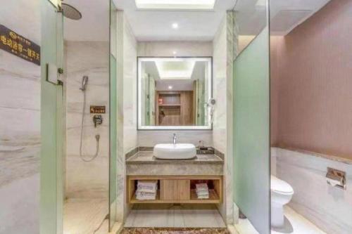 a bathroom with a sink and a shower and a toilet at Oriental Glory Hotel in Dongguan