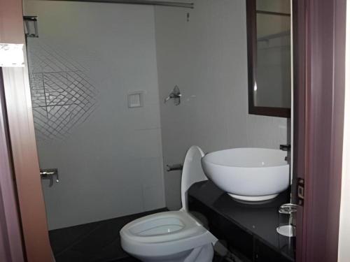 a bathroom with a white toilet and a sink at The Grande Suites in Surigao
