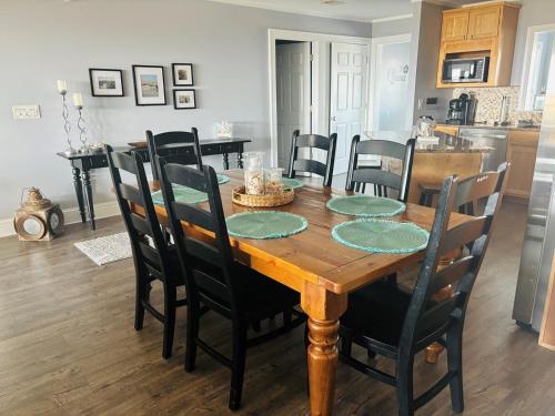a dining room with a wooden table and chairs at Ohana in Holden Beach