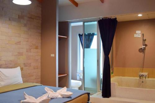 a bedroom with a bed and a bath tub and a bed sidx sidx at Z2 Boutique Hotel in Ban Samet