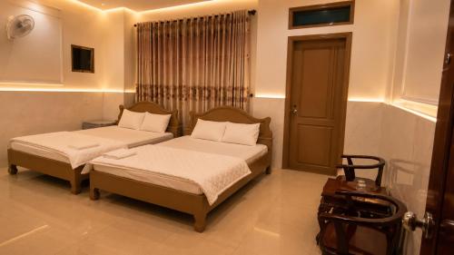a bedroom with two beds and a window at HOTEL HOA LU Buôn Ma Thuột in Buôn Kô Sir