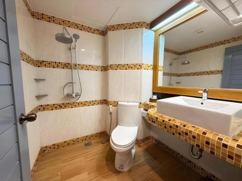 a bathroom with a sink and a toilet and a mirror at New Siya in Maha Sarakham