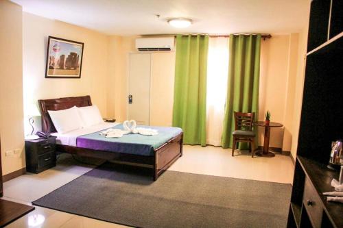a bedroom with a bed and a green curtain at Time Travellers Hotel in Manila