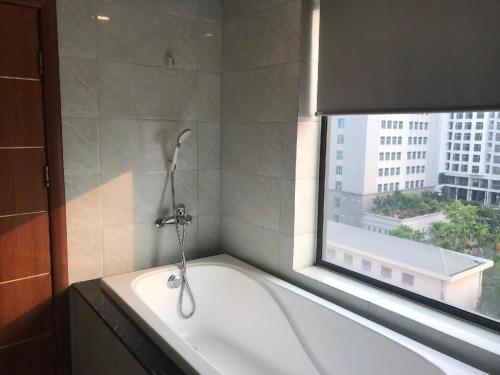 a bath tub in a bathroom with a window at Smart Hotel in Bắc Ninh