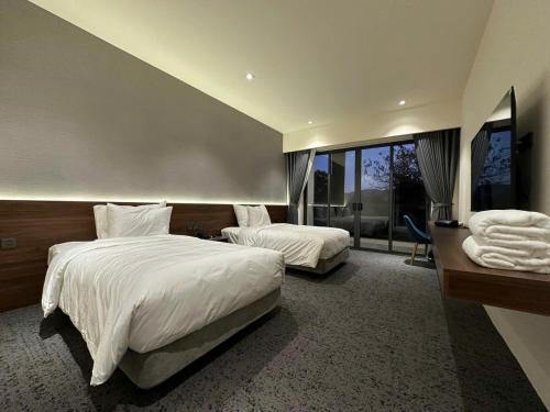 a hotel room with two beds and a large window at Mountain Hill in Mai Sơn