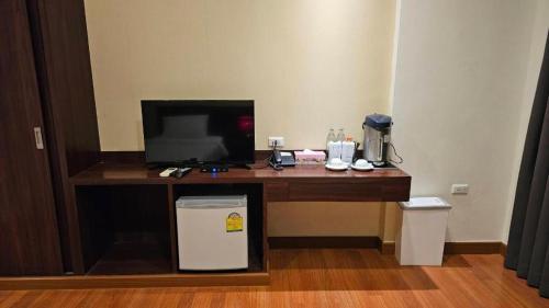 a desk with a television and a computer on it at King Hotel in Ban Tha Phae