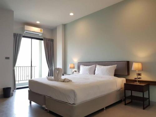 a bedroom with a large bed and a large window at @Sleep in Ban Rang Faet