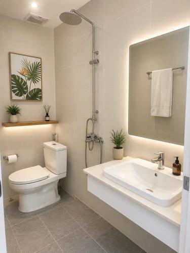 a bathroom with a toilet and a sink and a mirror at Blue Hotel Sunset Town Phu Quoc in Phú Quốc