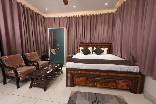 a bedroom with a bed and a couch and a chair at hotel baromas retreat in Jawālāpur