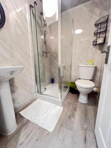 a bathroom with a shower and a toilet and a sink at Stratford Hotel in London