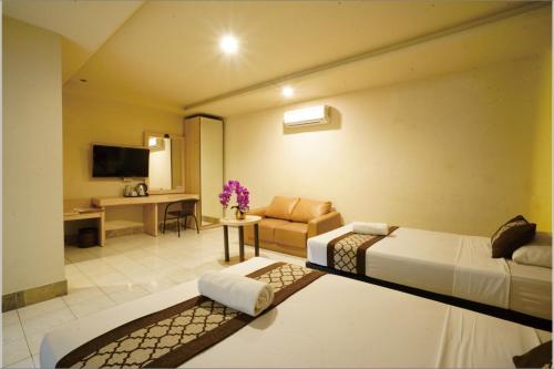 a hotel room with a bed and a desk at Hotel Grand Rosela in Yogyakarta