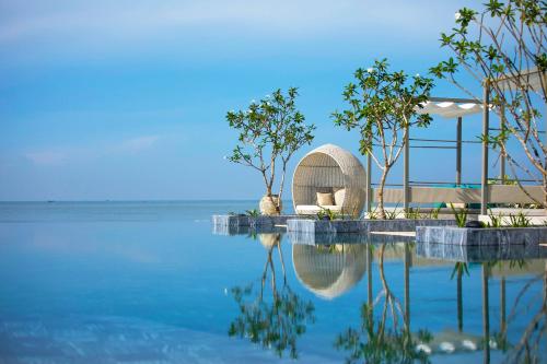 a pool of water with trees and a building at Meliá Ho Tram Beach Resort in Ho Tram