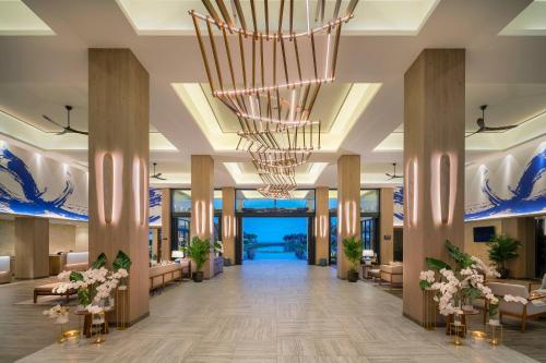 a lobby of a hotel with a large chandelier at Meliá Ho Tram Beach Resort in Ho Tram