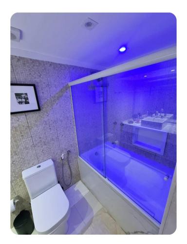 a bathroom with a toilet and a bath tub at Vitória Marina Flat in Salvador
