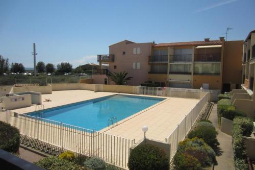 une grande piscine devant un immeuble dans l'établissement Aqua Plage, au Cap d'Agde