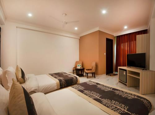 a hotel room with two beds and a flat screen tv at Hotel Apple Park - Near Delhi Airport, Free Airport Trasnfer in New Delhi