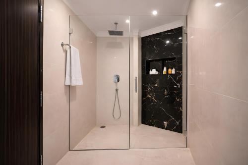 a shower with a glass door in a bathroom at Hotel Apple Park - Near Delhi Airport, Free Airport Trasnfer in New Delhi