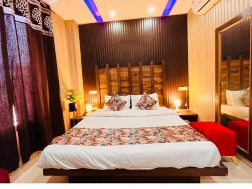 a bedroom with a large bed and a red chair at Hotel PG Grand in Mohali