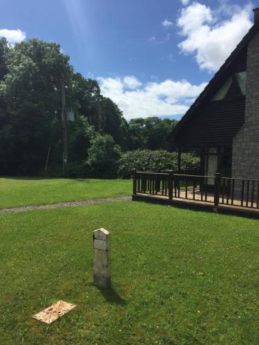 a stone pillar in the grass next to a building at Lodge in Portumna Ireland in Portumna