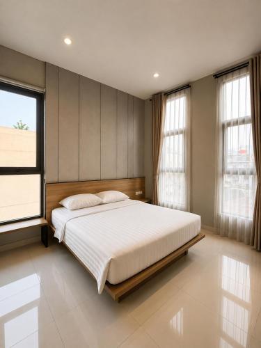 a bedroom with a large bed and a large window at Wisma Pelangi 1 in Jakarta