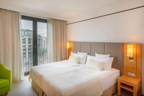 a hotel room with a bed and a large window at Meliá Berlin in Berlin