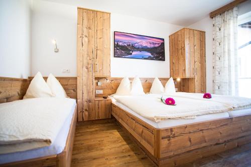 two beds in a room with wooden walls at Apartment Aster in Wagrain