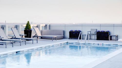 a pool on the roof of a building with lounge chairs at Arlington Fully Furnished Apartments in Crystal City in Arlington