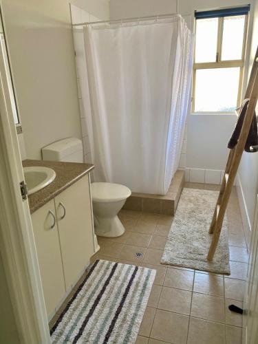 a white bathroom with a toilet and a sink at Villa LaNoah in Kalbarri