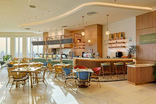 a restaurant with tables and chairs and a bar at Centara Grand at CentralWorld in Bangkok