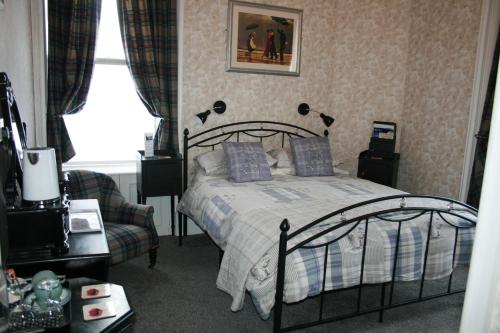 een slaapkamer met een bed, een stoel en een raam bij Ardmeanach in Inverness