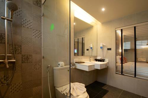 a bathroom with a toilet and a sink and a shower at Palm Galleria Resort in Khao Lak
