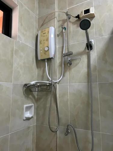 a shower in a bathroom with a phone on the wall at Nassim Hotel and Beach Resort in Casagan