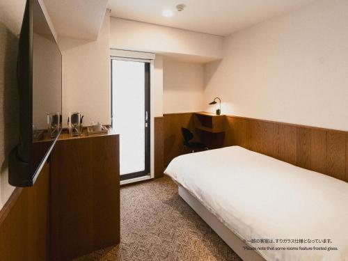 a hotel room with a bed and a television at WPÜ HOTEL Shinjuku in Tokyo
