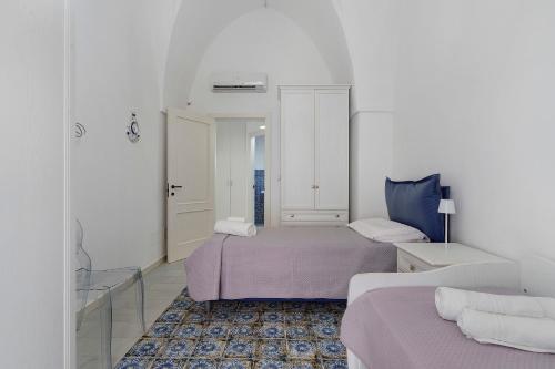 a white room with two beds and a couch at Dimora Collina 2 in Sannicola